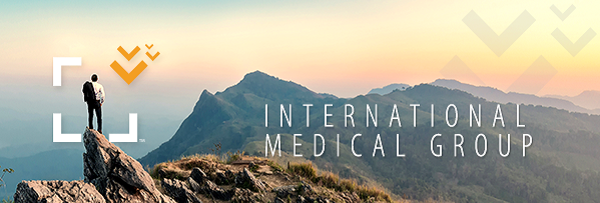 A person standing on a rocky mountain peak overlooking a vast mountain range at sunrise, representing the peace of mind provided by comprehensive travel insurance.